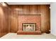Basement fireplace with brick surround and wood paneled walls at 11936 E Oregon Cir, Aurora, CO 80012