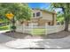 Well-maintained two-story home with a manicured lawn, white picket fence and mature trees at 11936 E Oregon Cir, Aurora, CO 80012