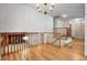 Bright hallway with hardwood floors, stairs to the lower level, and a decorative chandelier at 11936 E Oregon Cir, Aurora, CO 80012