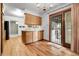 Well-lit kitchen featuring light wood cabinets, hardwood floors, and outdoor access at 11936 E Oregon Cir, Aurora, CO 80012