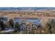 Aerial view of home with water view, natural landscape, bare trees, and mountains in the distance at 10667 E Goose Haven Dr, Lafayette, CO 80026