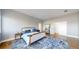 Bright bedroom featuring a tufted headboard, stylish rug and hardwood floors at 10667 E Goose Haven Dr, Lafayette, CO 80026