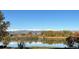 Scenic lake view with mature trees in foreground and snow capped mountains in the distance at 10667 E Goose Haven Dr, Lafayette, CO 80026