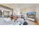 Comfortable living room featuring stone fireplace, vaulted ceiling, and view to the modern kitchen at 10667 E Goose Haven Dr, Lafayette, CO 80026