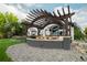 Outdoor patio with dark wooden pergola, built in barbeque, and outdoor seating at 10667 E Goose Haven Dr, Lafayette, CO 80026