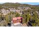 Aerial view of the home nestled in a lush, wooded landscape with mountain views at 4520 Forest Hill Rd, Evergreen, CO 80439