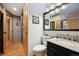 Bathroom with wood floors and cabinet sink and doorway to hallway at 4520 Forest Hill Rd, Evergreen, CO 80439