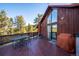 Outdoor deck featuring outdoor table with grill with forested view at 4520 Forest Hill Rd, Evergreen, CO 80439