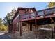 Exterior view showcases the spacious deck and a stone foundation at 4520 Forest Hill Rd, Evergreen, CO 80439