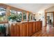 Hallway featuring wooden built-ins, wood floors, many windows providing natural light, and plants at 4520 Forest Hill Rd, Evergreen, CO 80439