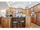 Kitchen with custom wood cabinetry, a breakfast bar, and modern appliances under a skylight at 4520 Forest Hill Rd, Evergreen, CO 80439