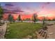 Expansive backyard with lush green grass, mature trees, and privacy fencing at 9650 Raven St, Firestone, CO 80504