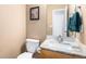 Bathroom with a wood cabinet, marble countertop, sink, toilet, and a picture hanging on the wall at 9650 Raven St, Firestone, CO 80504