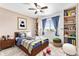 Bright bedroom with a ceiling fan, a bed, built in shelves and two ottomans for relaxing at 9650 Raven St, Firestone, CO 80504