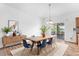 Dining room with wood floors, modern decor, and sliding door leading to an outdoor deck at 9650 Raven St, Firestone, CO 80504