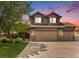 Inviting two-story home featuring a stone facade, attached garage, and manicured lawn at 9650 Raven St, Firestone, CO 80504
