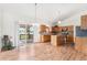 Bright eat-in kitchen features wood floors, center island, stainless appliances, and sliding door to deck at 9650 Raven St, Firestone, CO 80504