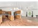 Open-concept kitchen with hardwood floors, stainless appliances, and center island at 9650 Raven St, Firestone, CO 80504