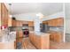 Open kitchen with island, stainless appliances, and ample countertop space at 9650 Raven St, Firestone, CO 80504