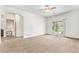 Spacious carpeted living room with ceiling fan, sliding door to the backyard, and adjacent office area at 9650 Raven St, Firestone, CO 80504