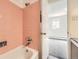 Retro pink tiled shower and tub with modern fixtures seen from a bedroom doorway at 1265 Colorado Blvd # 12, Denver, CO 80206