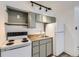 Compact kitchen featuring white appliances, olive colored cabinets, and wood-look countertops at 1265 Colorado Blvd # 12, Denver, CO 80206