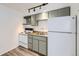 Efficient kitchen space with a white refrigerator and stove, complemented by neutral toned cabinets and wood counters at 1265 Colorado Blvd # 12, Denver, CO 80206