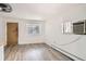 Bright living room featuring modern vinyl floors, a unique glass block window, and neutral wall color at 1265 Colorado Blvd # 12, Denver, CO 80206
