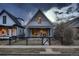 Charming home featuring a welcoming front porch, gray siding, and black metal fence at 1181 S Clarkson St, Denver, CO 80210