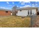 Large back yard features a lawn, detached garage, and a partial fence at 6270 Harlan St, Arvada, CO 80003