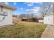 Back yard features a large lawn, white siding on the house, and a white storage shed at 6270 Harlan St, Arvada, CO 80003