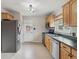 Well-lit kitchen featuring stainless steel appliances and wood cabinetry at 6270 Harlan St, Arvada, CO 80003