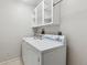 Laundry room features bright white shelving, a white washer and dryer, and tile flooring at 6270 Harlan St, Arvada, CO 80003