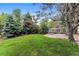 A lush green backyard with mature trees and a charming stone patio creates a peaceful outdoor oasis at 3145 W 31St Ave, Denver, CO 80211