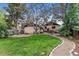 Expansive backyard featuring a stone patio, walkway, mature trees, and well-manicured lawn offers inviting outdoor space at 3145 W 31St Ave, Denver, CO 80211