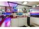 Custom basement bar with neon lighting, full bar setup, and refrigerator at 3145 W 31St Ave, Denver, CO 80211