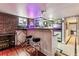 Basement bar with exposed brick wall, neon beer signs, barstools, and hardwood flooring at 3145 W 31St Ave, Denver, CO 80211