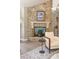 Close up of stone fireplace with mounted art, decorative mantle, and a cozy chair at 3401 E Kentucky Ave, Denver, CO 80209