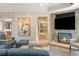 Comfortable living room featuring a stone fireplace, large TV, and modern furnishings at 3401 E Kentucky Ave, Denver, CO 80209