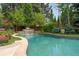Beautiful backyard featuring a refreshing pool, soothing waterfall, and abundant greenery at 3401 E Kentucky Ave, Denver, CO 80209