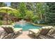 Beautiful backyard with a swimming pool, waterfall feature, and comfortable lounge chairs at 3401 E Kentucky Ave, Denver, CO 80209