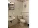 Cozy bathroom with a toilet, sink, and open storage at 11318 Clermont Dr, Thornton, CO 80233