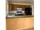 Kitchen view featuring wood cabinetry, appliances and a peninsula counter at 11318 Clermont Dr, Thornton, CO 80233