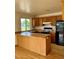 A kitchen featuring wood cabinets, black appliances, and an island at 11318 Clermont Dr, Thornton, CO 80233