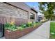 Beautiful landscaping with lush greenery lining the walkway in front of the brick Root Down building at 2640 Central Ct # 104, Denver, CO 80211