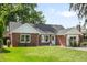 Charming brick home with a well-manicured lawn, lovely landscaping, and eye-catching architectural details at 2635 Kearney St, Denver, CO 80207