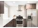 Well-equipped kitchen featuring stainless steel appliances, modern cabinetry, and a stylish range hood at 2635 Kearney St, Denver, CO 80207