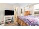 Bedroom featuring a wooden dresser, wooden bed frame, purple comforter, wood flooring and an open door to another room at 3930 W Kentucky Ave, Denver, CO 80219