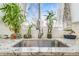 Close-up of kitchen sink featuring granite countertops and a window with greenery at 3930 W Kentucky Ave, Denver, CO 80219