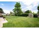 Expansive backyard featuring lush lawn, mature trees, a garden, and greenhouse on a sunny day at 6666 S Pennsylvania St, Centennial, CO 80121